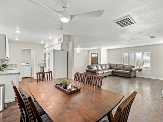 dining room featuring a wealth of natural light, visible vents, washer / clothes dryer, and dark wood-style flooring