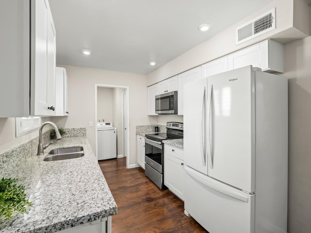 kitchen featuring washer / dryer, visible vents, white cabinets, stainless steel appliances, and a sink