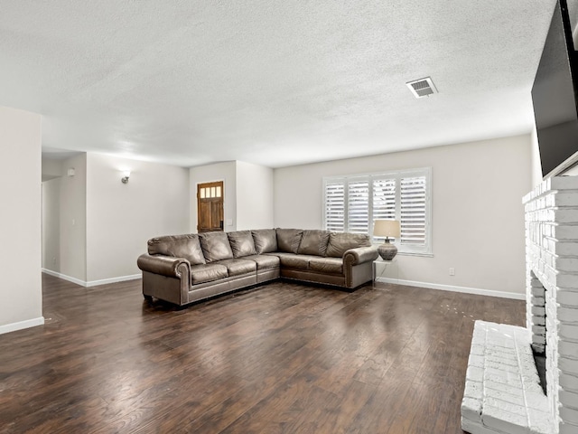 living area with a brick fireplace, wood finished floors, visible vents, and baseboards