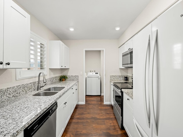 kitchen with stainless steel appliances, dark wood-type flooring, white cabinetry, a sink, and light stone countertops