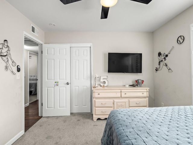 bedroom with a closet, light colored carpet, visible vents, a ceiling fan, and baseboards