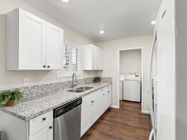 kitchen with washing machine and dryer, a sink, dark wood-style floors, freestanding refrigerator, and dishwasher