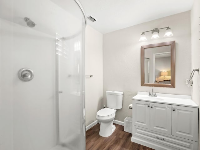 full bathroom featuring toilet, wood finished floors, vanity, visible vents, and a shower stall