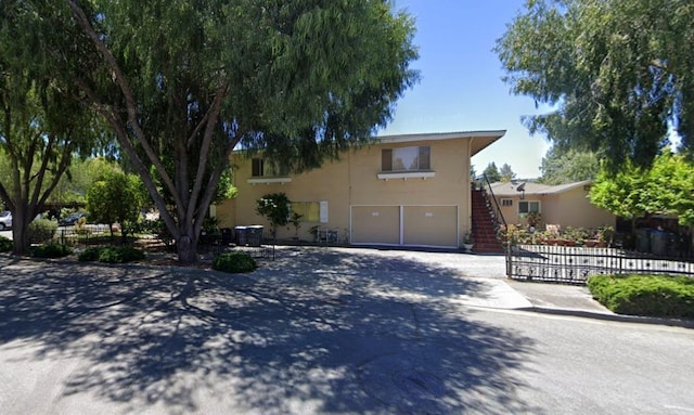 view of front of property with central AC unit and a garage