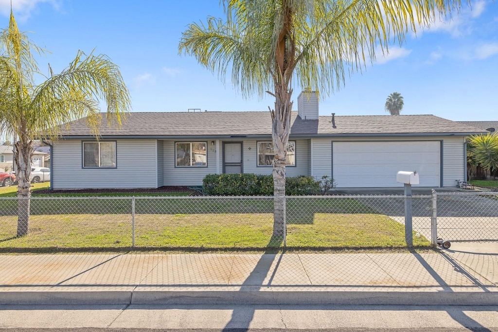 ranch-style home featuring a garage and a front lawn