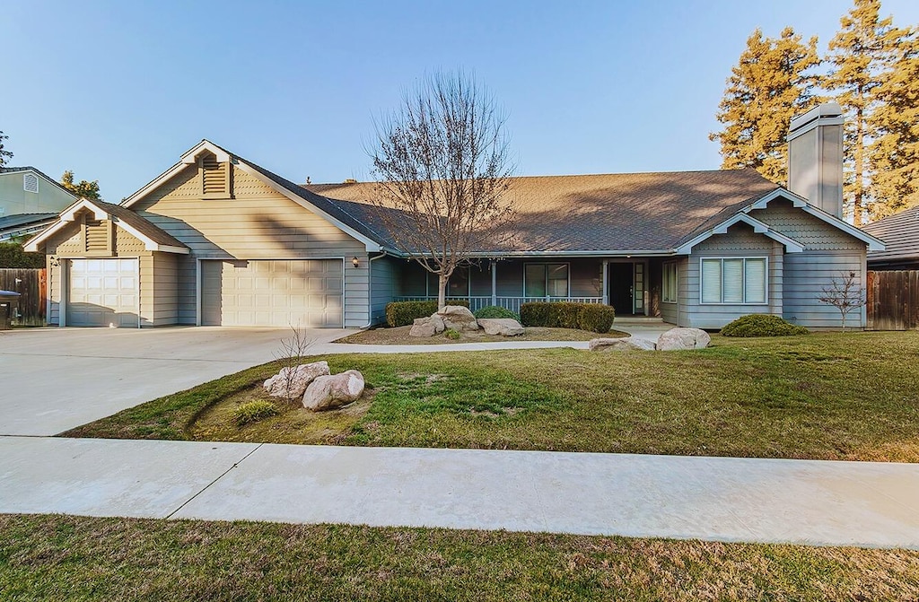 ranch-style house with a garage and a front lawn