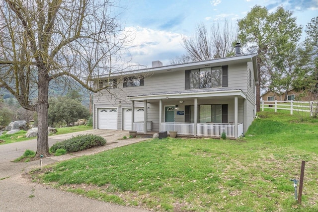 view of front of property featuring covered porch, a front yard, and a garage