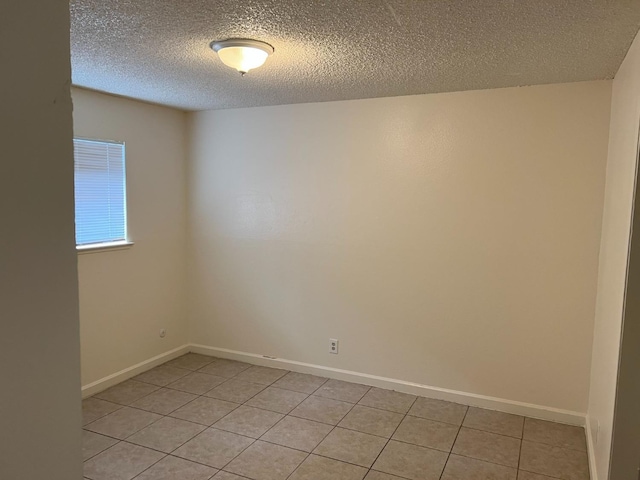 tiled spare room featuring a textured ceiling