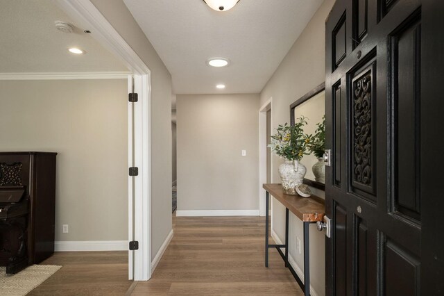 hallway featuring hardwood / wood-style floors and ornamental molding