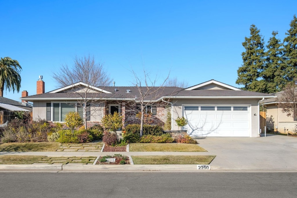 ranch-style home featuring concrete driveway, brick siding, and an attached garage