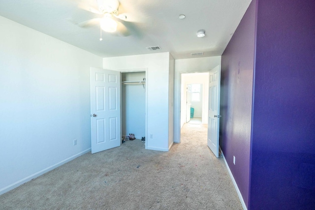 unfurnished bedroom with a closet, light carpet, and ceiling fan