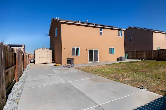 back of house with a patio area, a storage unit, and a yard