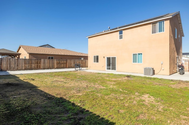 rear view of property with cooling unit, a patio, and a lawn