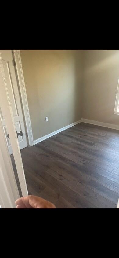 empty room with dark wood-type flooring