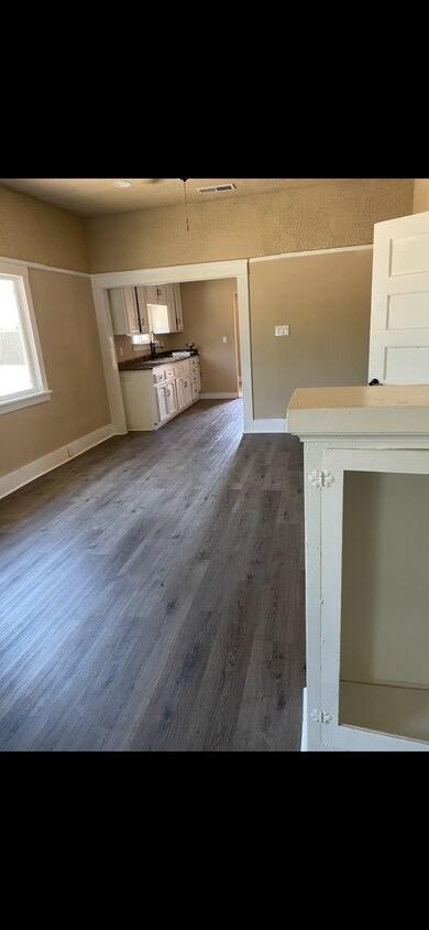 unfurnished living room featuring dark hardwood / wood-style flooring and sink