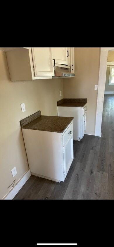 kitchen featuring white cabinets and dark wood-type flooring