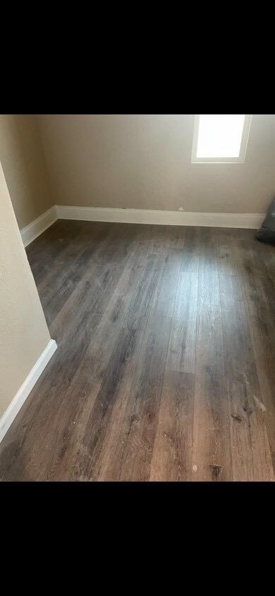 empty room with dark hardwood / wood-style flooring