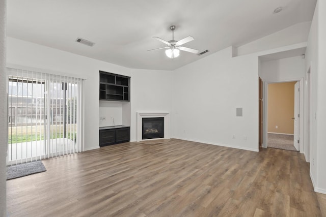 unfurnished living room featuring ceiling fan, vaulted ceiling, and hardwood / wood-style flooring