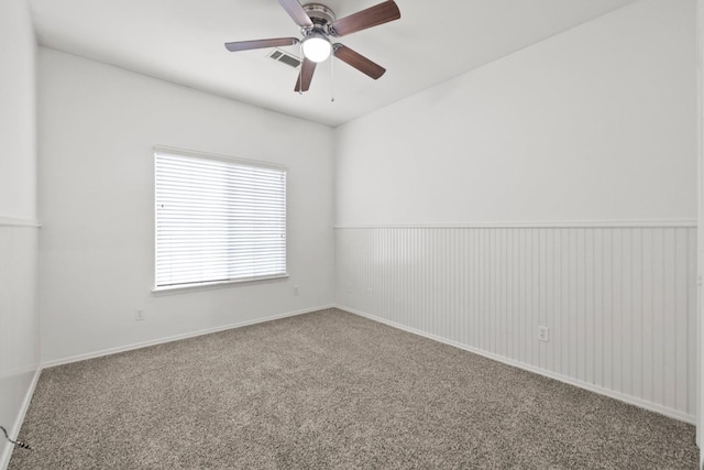 carpeted spare room with ceiling fan