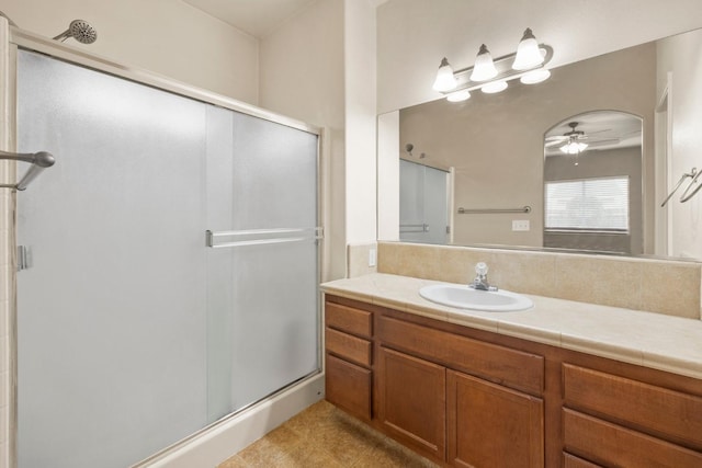 bathroom featuring ceiling fan, walk in shower, and vanity