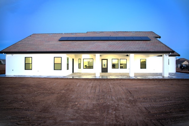 view of front of house with solar panels and a patio