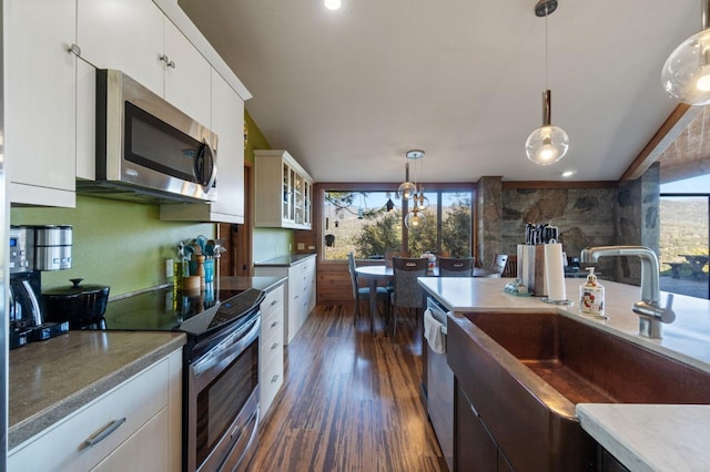 kitchen with stainless steel appliances, pendant lighting, dark hardwood / wood-style floors, white cabinets, and sink