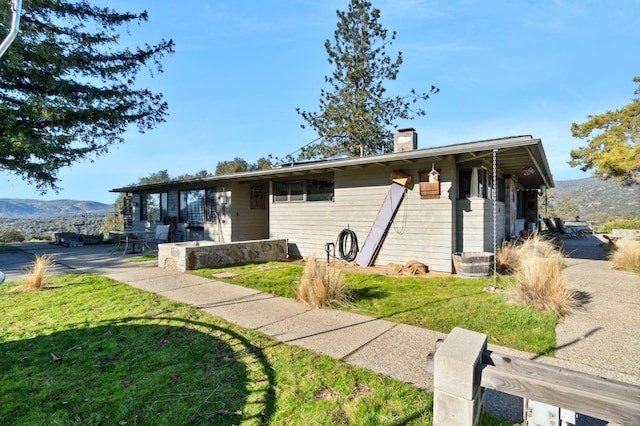 view of front of home featuring a front yard and a mountain view