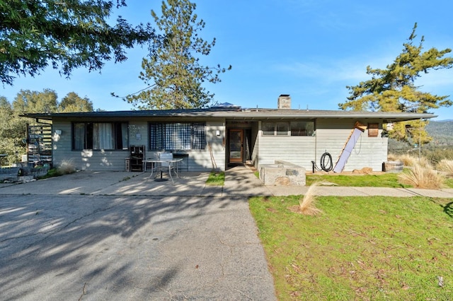 ranch-style home with a front yard and a patio