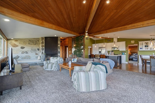 carpeted living room with wooden ceiling, a fireplace, and lofted ceiling with beams