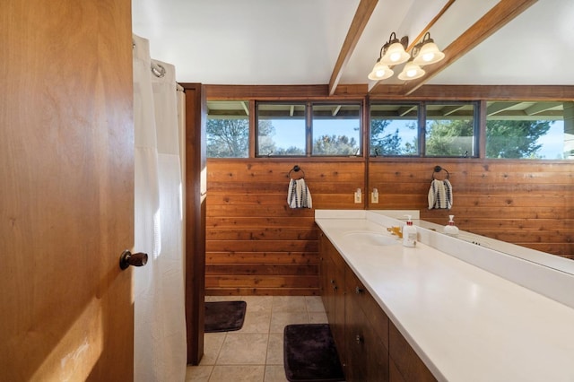 bathroom featuring tile patterned flooring, wooden walls, a wealth of natural light, and beamed ceiling