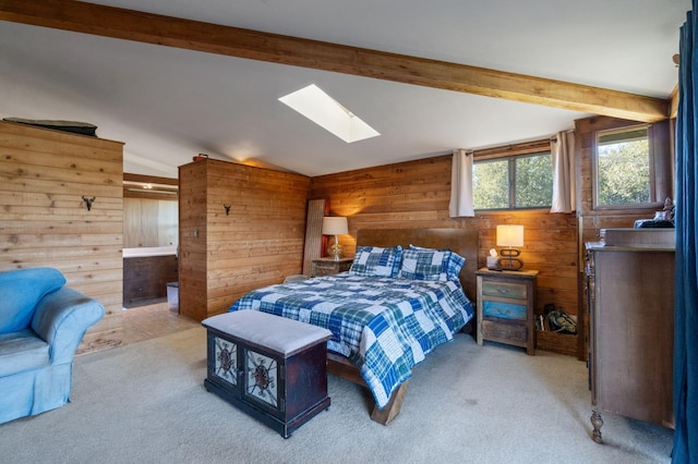 carpeted bedroom with wooden walls and vaulted ceiling with skylight