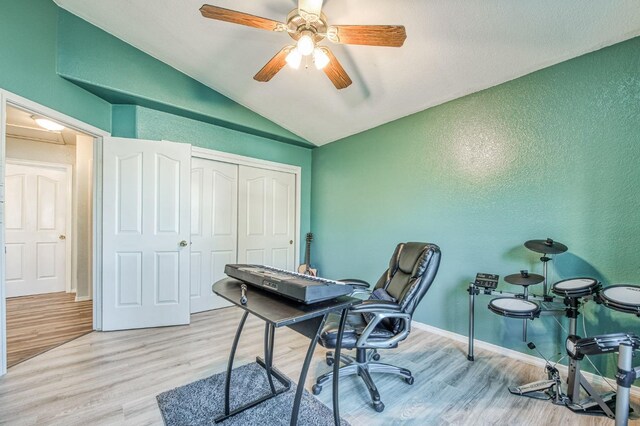 home office with ceiling fan, vaulted ceiling, and light hardwood / wood-style flooring