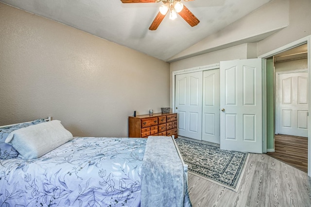 bedroom featuring lofted ceiling, ceiling fan, light hardwood / wood-style flooring, and a closet