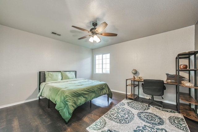 bedroom with baseboards, visible vents, dark wood finished floors, a ceiling fan, and a textured ceiling