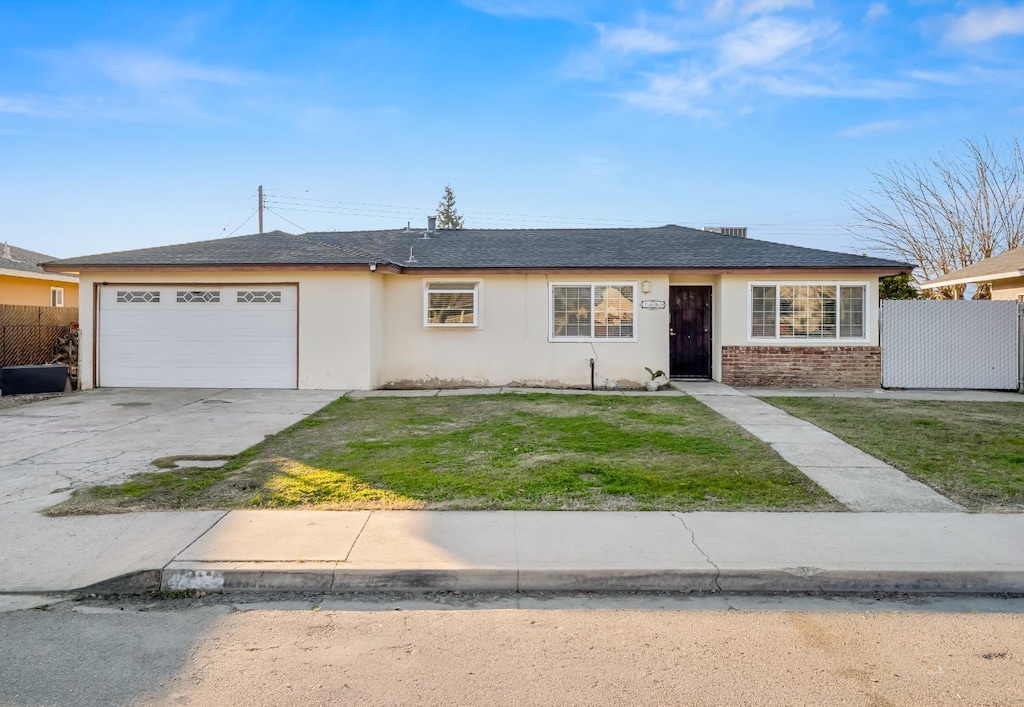 single story home with a garage and a front yard