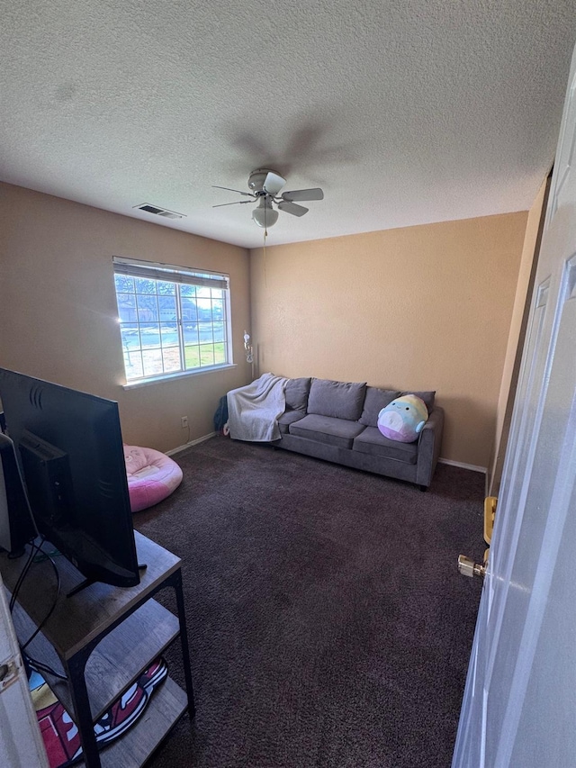 living room featuring ceiling fan, carpet flooring, visible vents, and baseboards