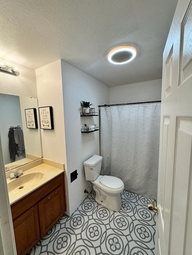 bathroom featuring a textured ceiling, vanity, toilet, and a shower with curtain