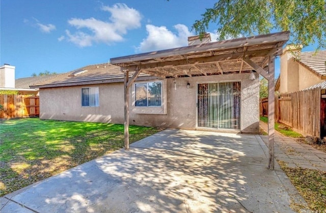 rear view of property featuring a patio, a fenced backyard, a yard, a pergola, and stucco siding