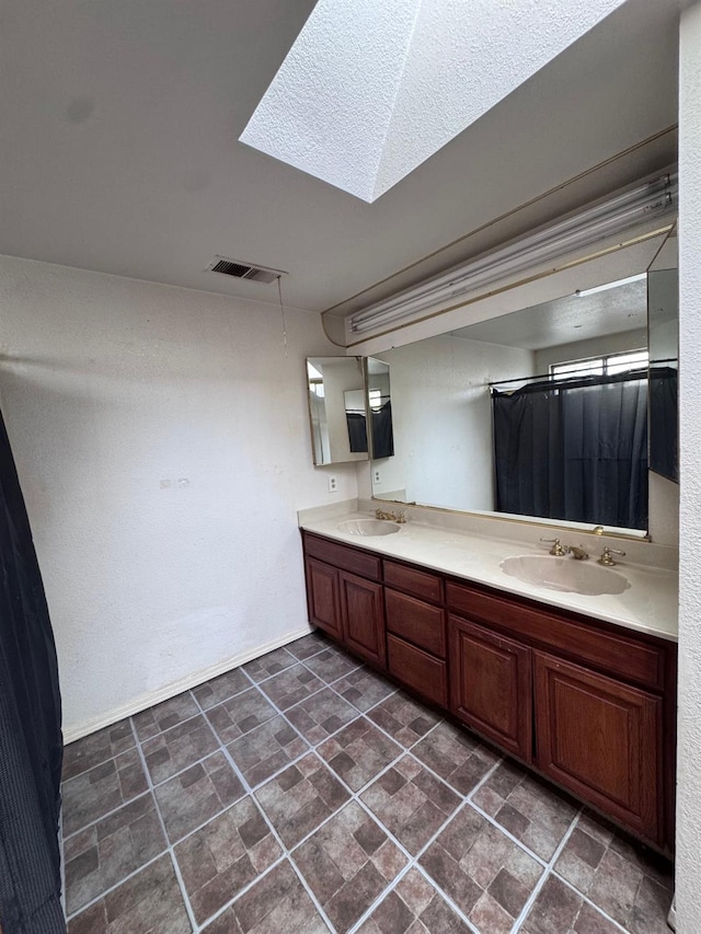 bathroom with a skylight and vanity