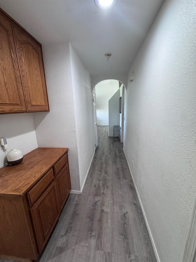 corridor with hardwood / wood-style flooring