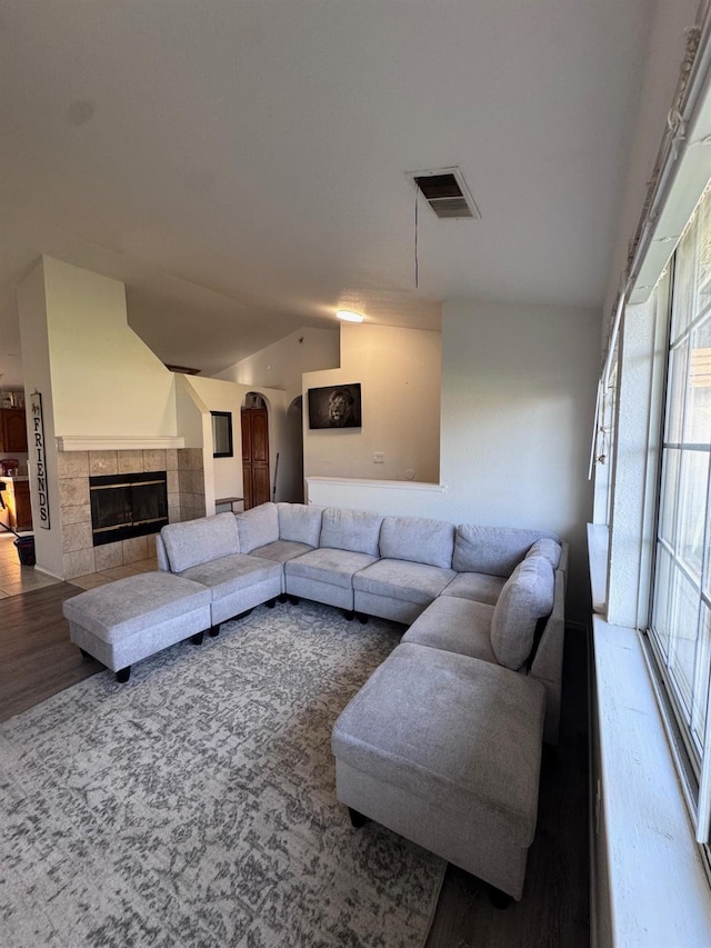 living room with hardwood / wood-style flooring, a fireplace, and vaulted ceiling