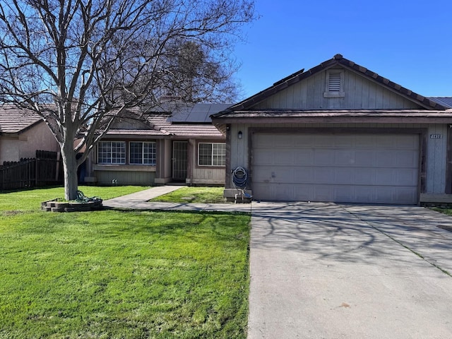 ranch-style home with a garage, a front lawn, and solar panels