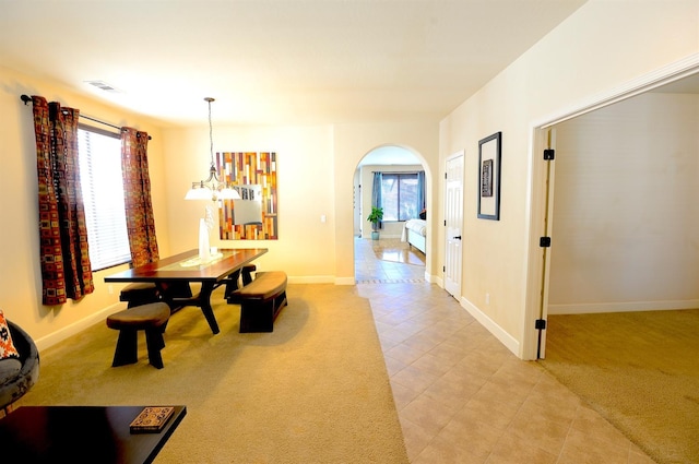 dining area with a chandelier and light colored carpet