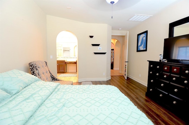 bedroom featuring dark wood-type flooring, ceiling fan, and connected bathroom