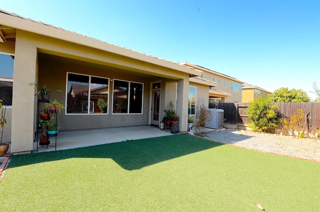 rear view of house with central AC unit and a patio