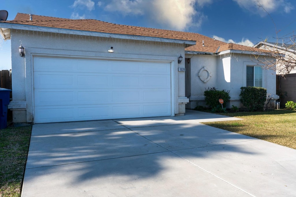 ranch-style home with a garage and a front lawn