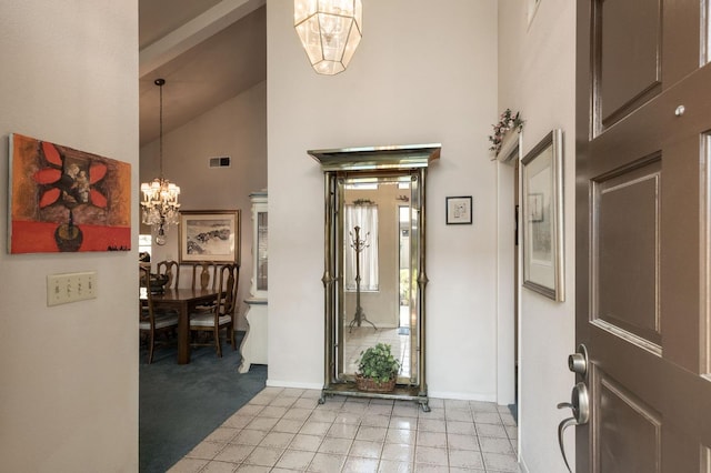 foyer entrance featuring a chandelier, high vaulted ceiling, visible vents, and baseboards