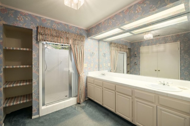 bathroom with double vanity, wallpapered walls, a shower stall, and a sink