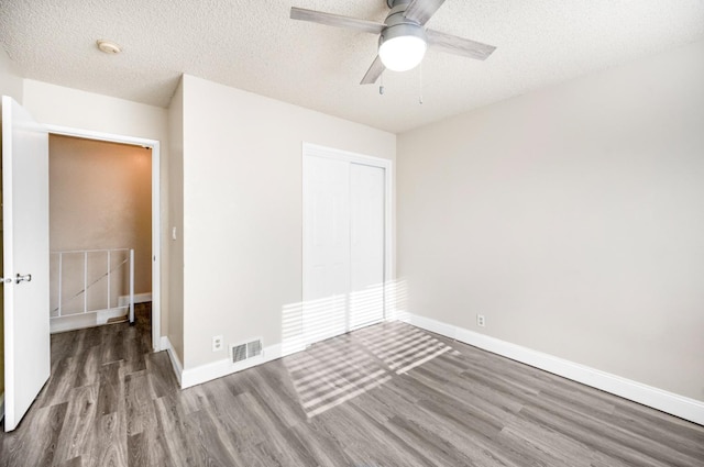 unfurnished room with a textured ceiling, ceiling fan, and hardwood / wood-style floors