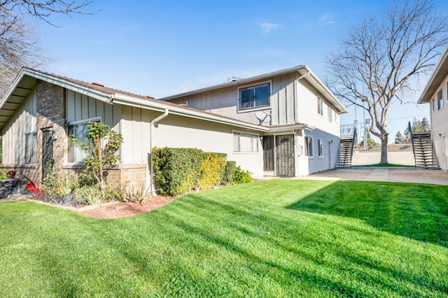 rear view of house featuring a patio and a lawn